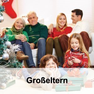 Drei Generationen Familie neben einem Weihnachtsbaum auf einem Sofa sitzend